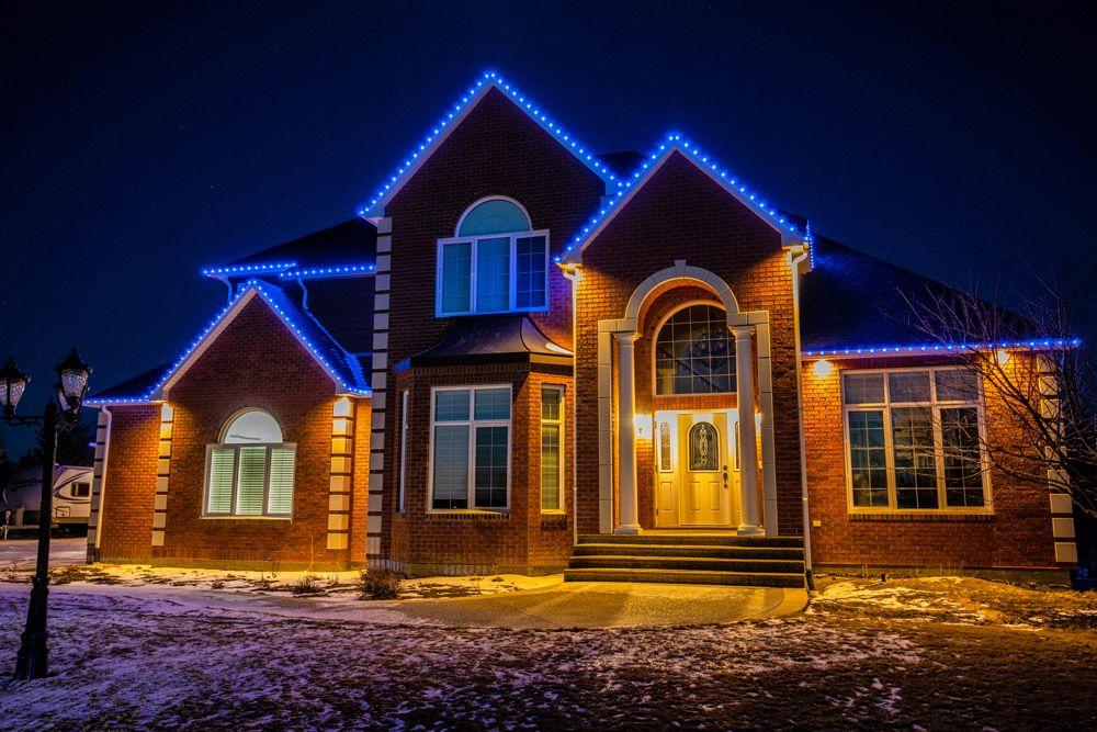 Home with permanent LED roofline lighting at night
