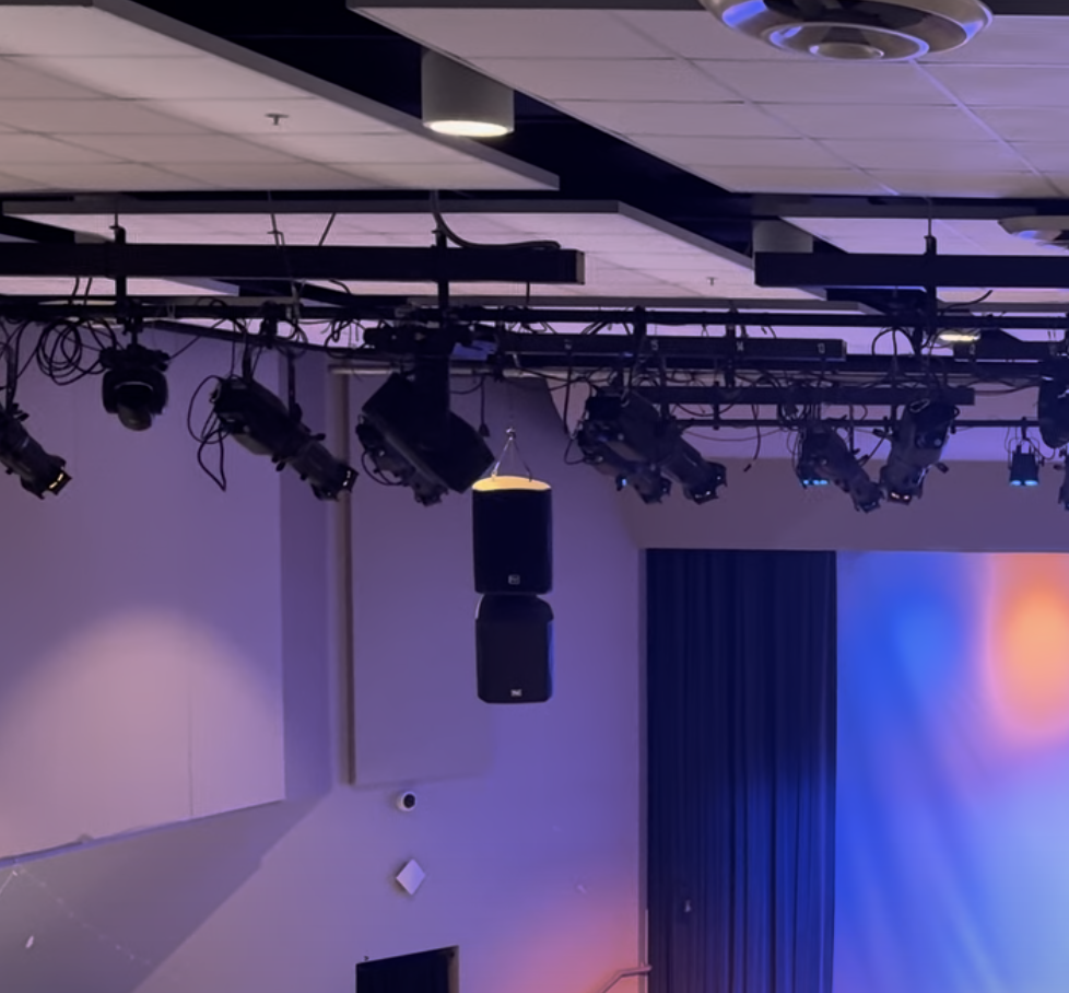Truss-mounted intelligent lighting fixtures above an event floor