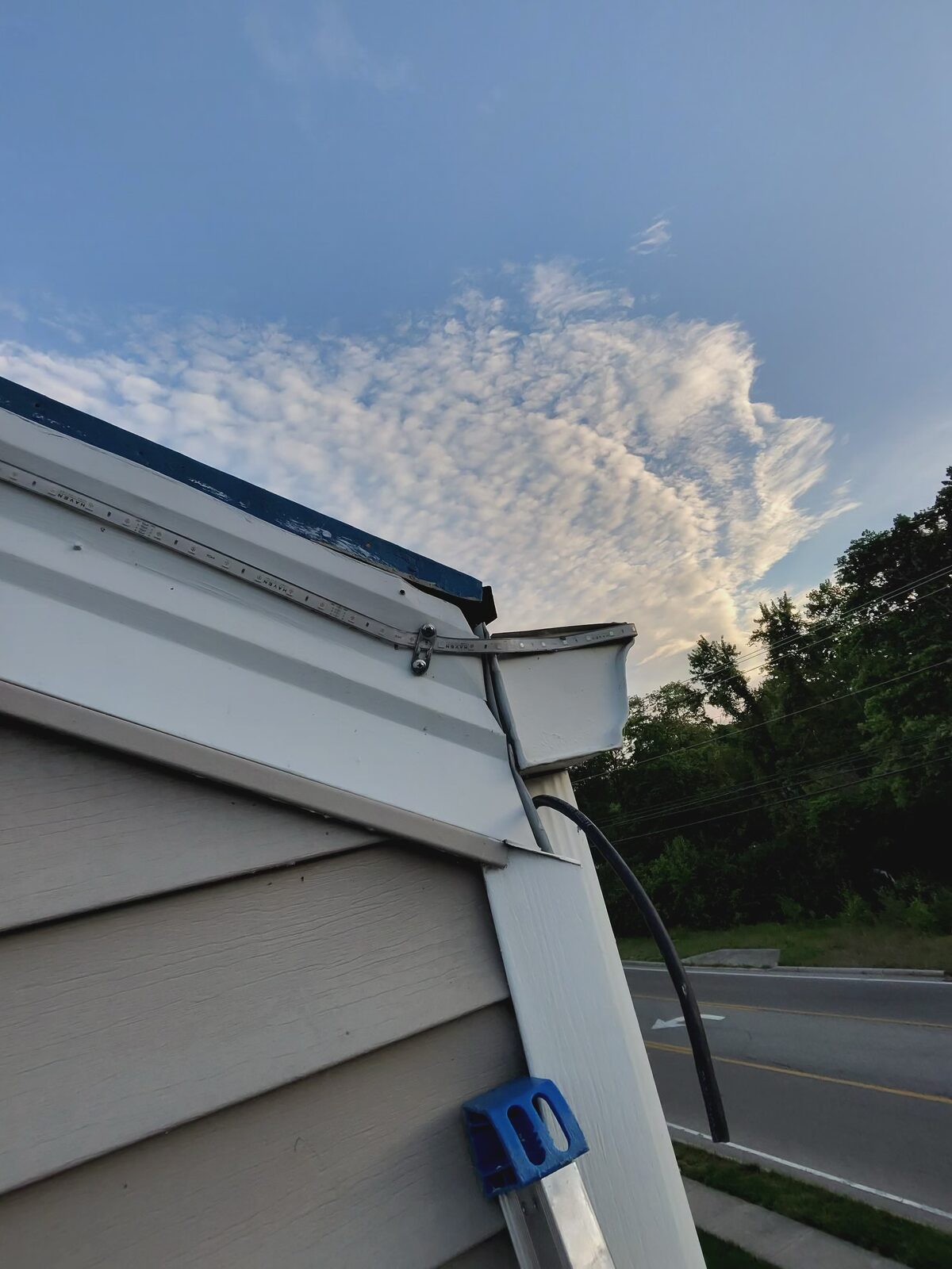 Previous installer's roofline wiring hanging loose down the side of Cozy's