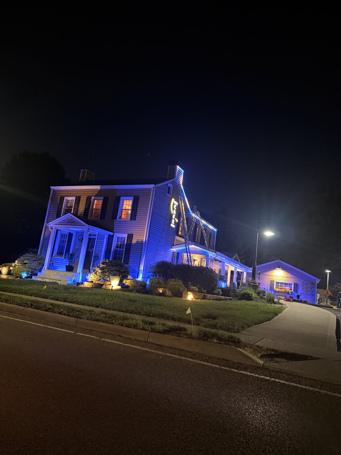 Cozy's Cafe and Pub lit up at night, seen from the street