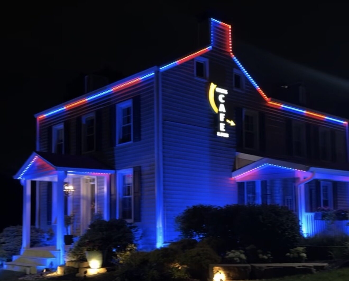 Cozy's Cafe and Pub at night with red and blue permanent roofline lighting